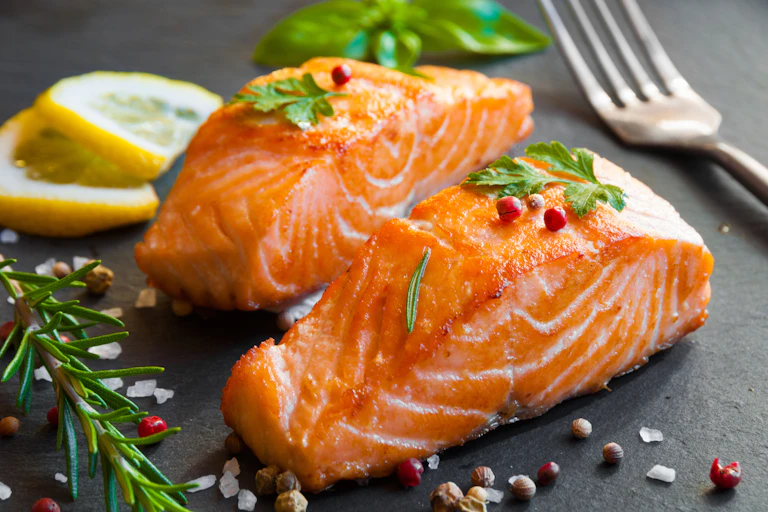 cooked salmon fillets on a plate with a garnish