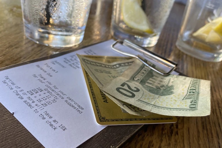 A photograph taken on Aug. 24, 2024, shows a bill, with cash for the tip, left on a restaurant table in Los Angeles.