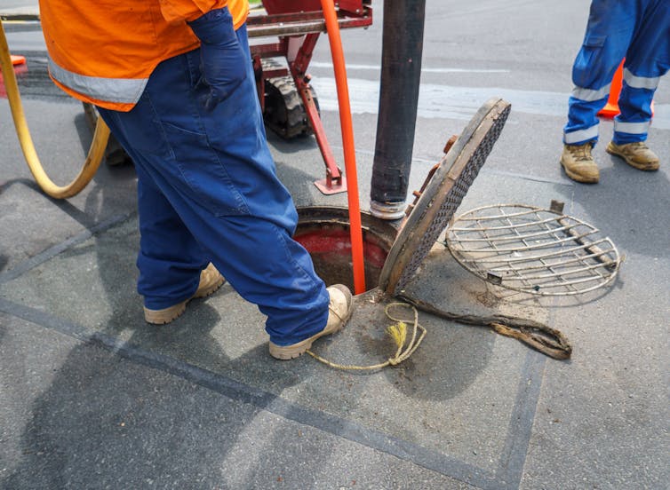 Cropped image of workers unblocking sewage pipes in Auckland.