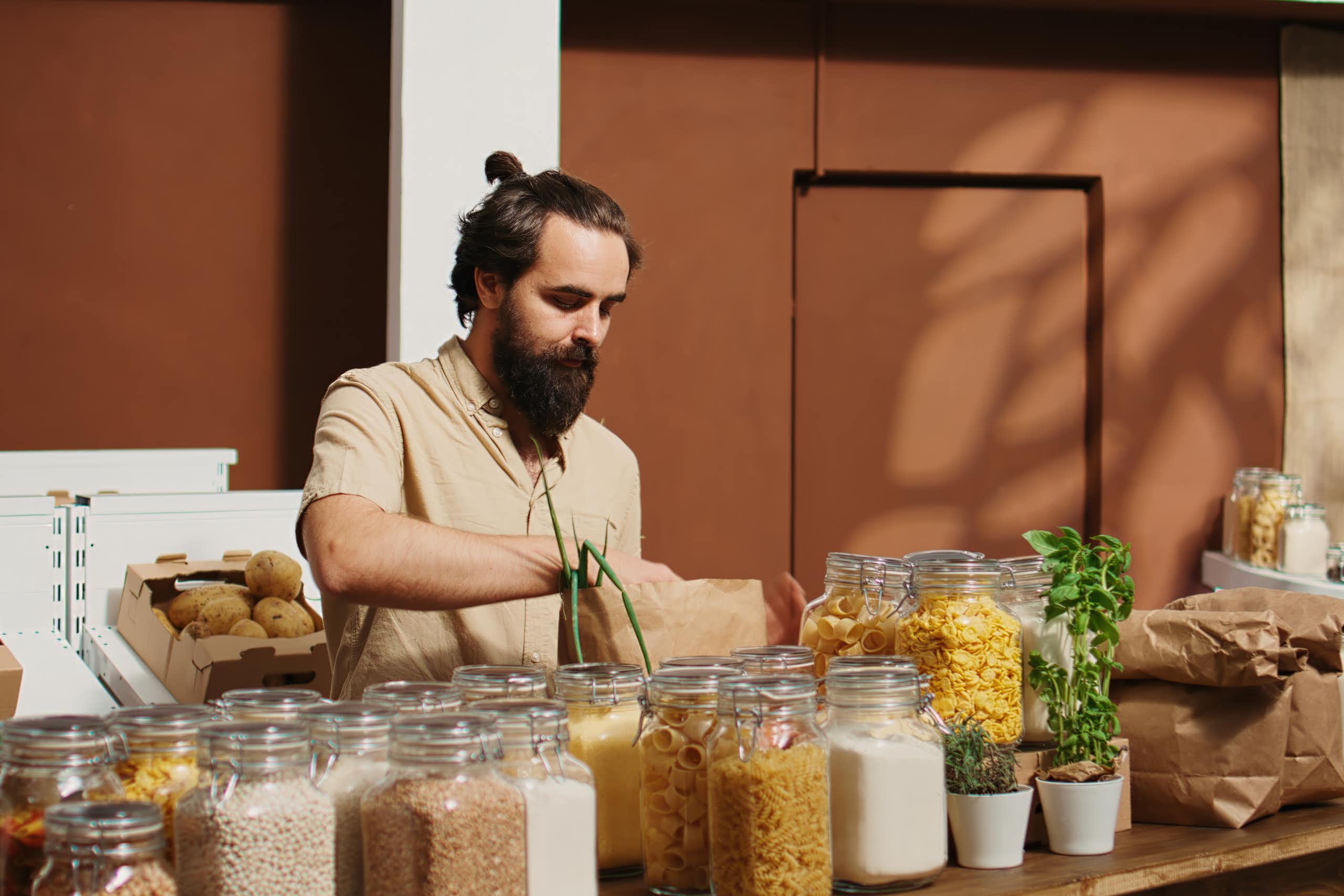 A man fills jars with food.