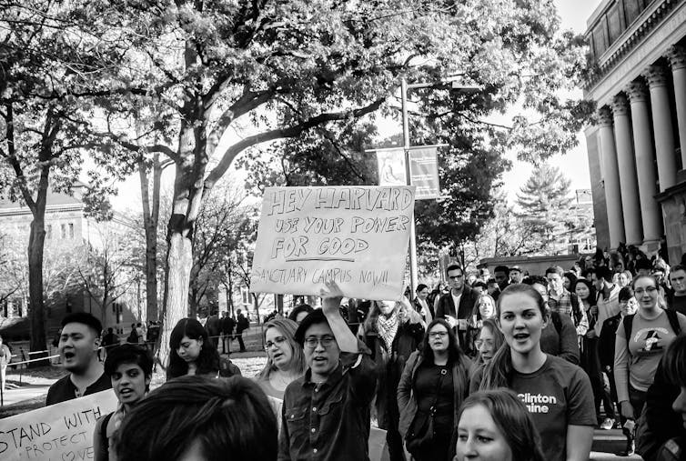 Students in Harvard protesting holding a sign saying