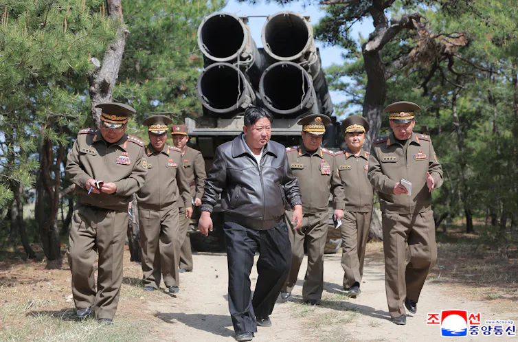 North Korean leader Kim Jong-un walking with a group of military personnel.