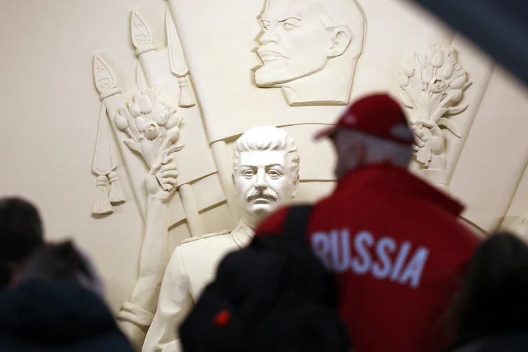 People walk in front of a statue of Joseph Stalin in a Moscow metro station.
