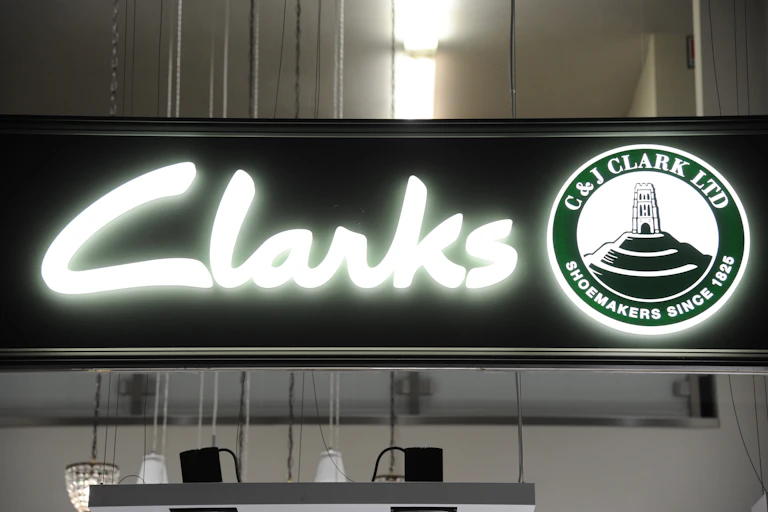 illuminated sign on the front of a clarks shoe shop