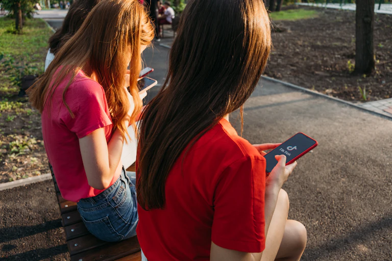Trois filles discutent avec leurs smartphones dans un parc à Kropivnitskiy, Ukraine, en juin 2020.