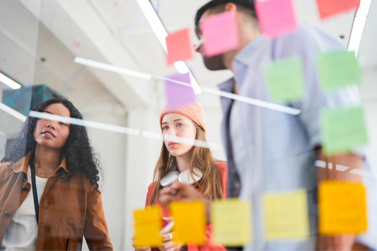 Trois salariés devant des post-it.