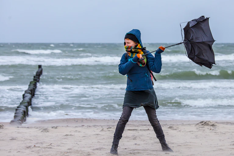 femme contre la tempete sur la plage