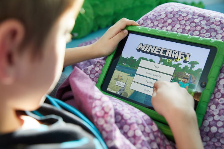 A young person taps at a screen.