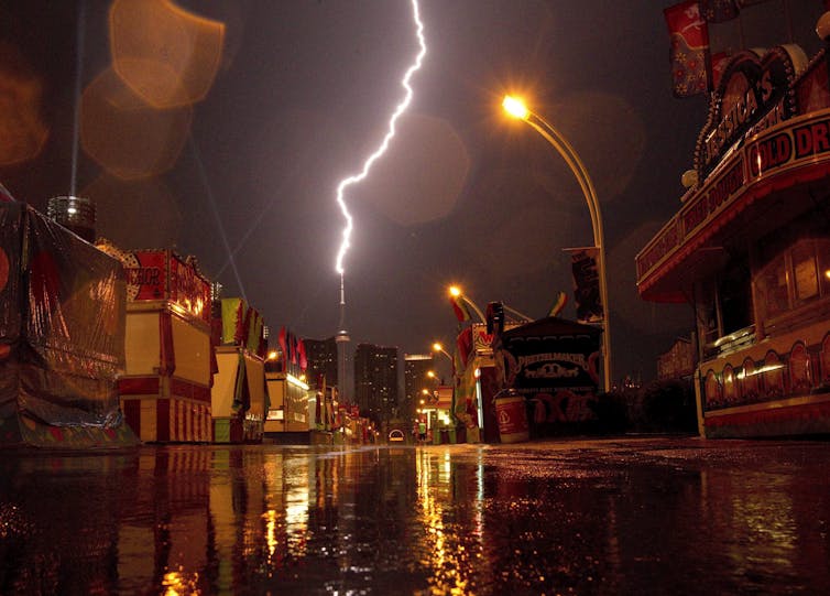 El paisaje urbano y las luces de los rayos golpean el edificio de fondo por la noche