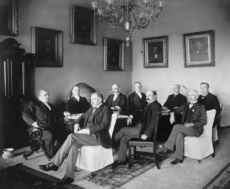 Bland and white photo of American politicians from 1895 sitting in a drawing room.