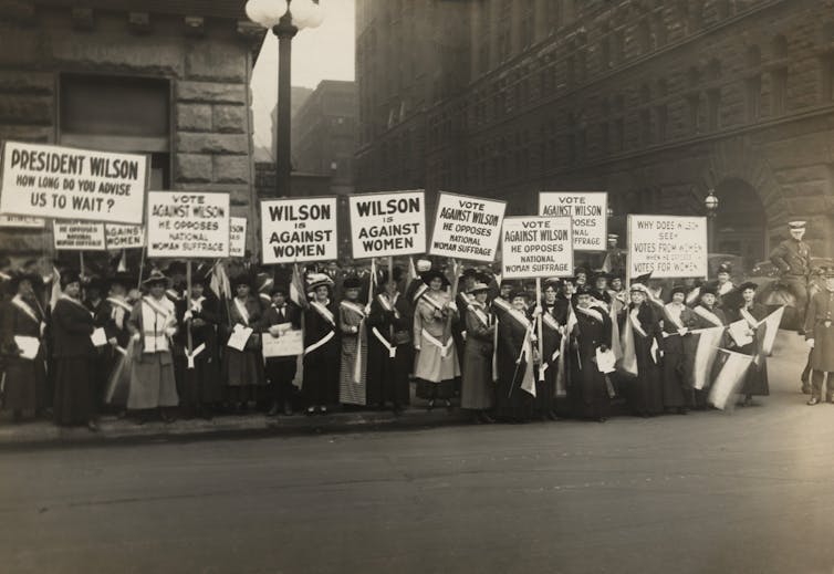 Black and white photo from 1916 of American suffrage supporters protesting in the street.