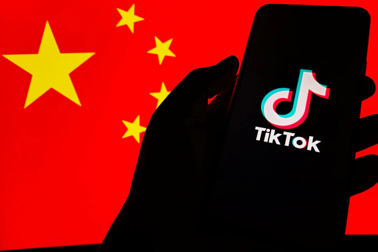 phone screen showing tiktok logo against the backdrop of a chinese flag