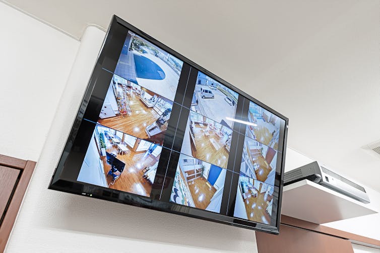 A large screen mounted on a wall shows nine scenes around a facility.