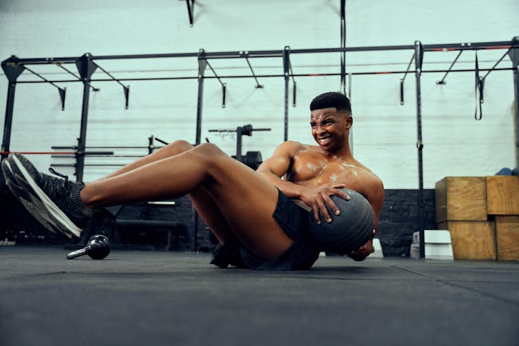 Skip the ice bathtub if you need larger muscle tissue 1 A young man doing an intense workout with a medicine ball.