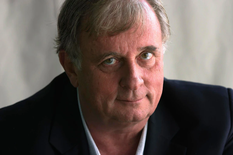 Edmund White in a suit looking to camera