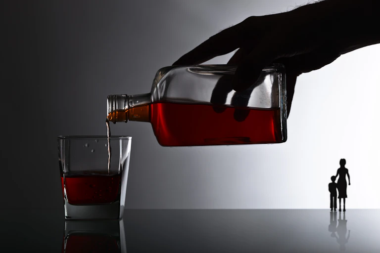 Illustration d'une main versant de l'alcool dans un verre. À l'arrière-plan, deux silhouettes de mère et d'enfant se tiennent debout.