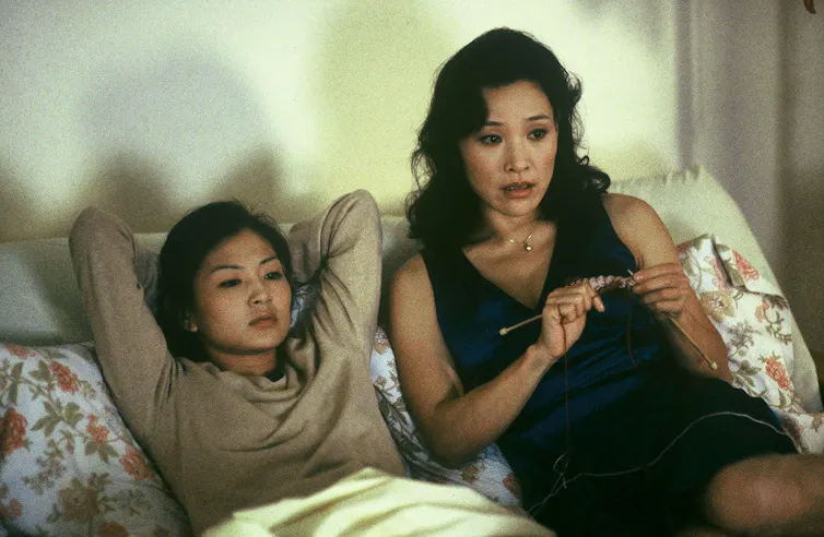 A mother and a daughter lie in bed.