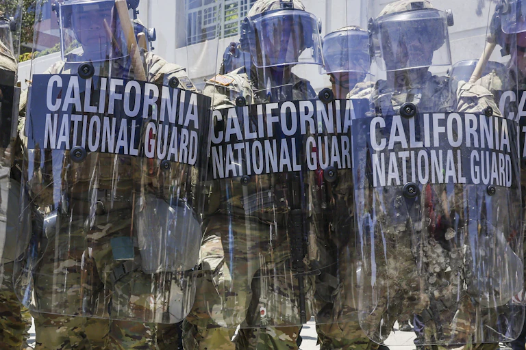 National Guard troops holding riot shields on the streets of Los Angeles.