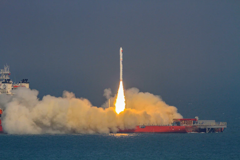 A rocket carrying four satellites into low Earth orbit launches from a ship at sea, in China.