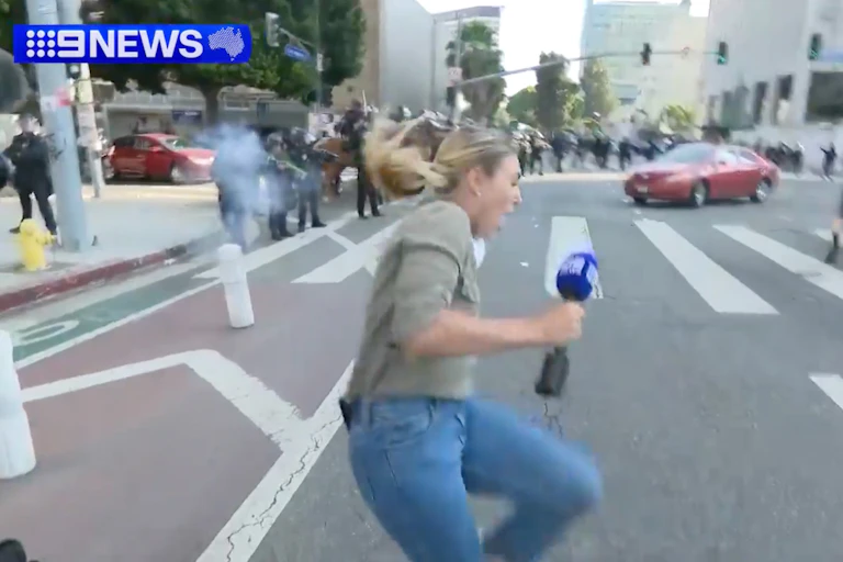 Correspondent Lauren Tomasi reacts after being hit by a rubber bullet.