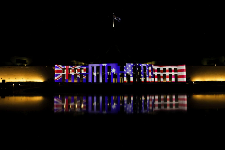 The Australian and US flags projected on Parliament House Canberra