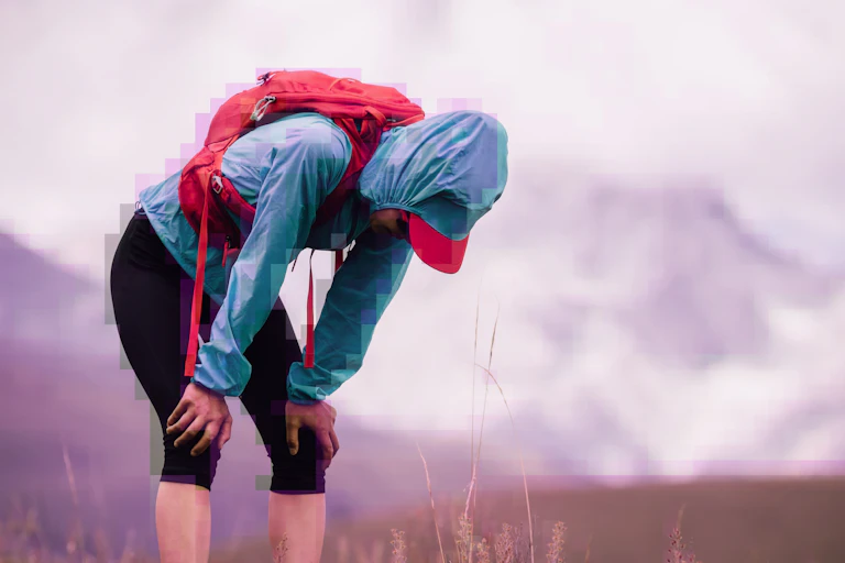 A tired trail runner in bright clothes bending over catching their breath, subtle glitch effect overlay.