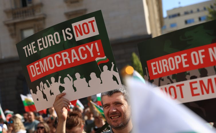 A protestor holds a sign reading 'The euro is not democracy'.