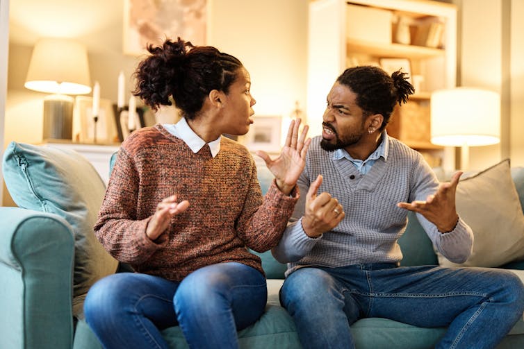 a woman and man on a sofa argue