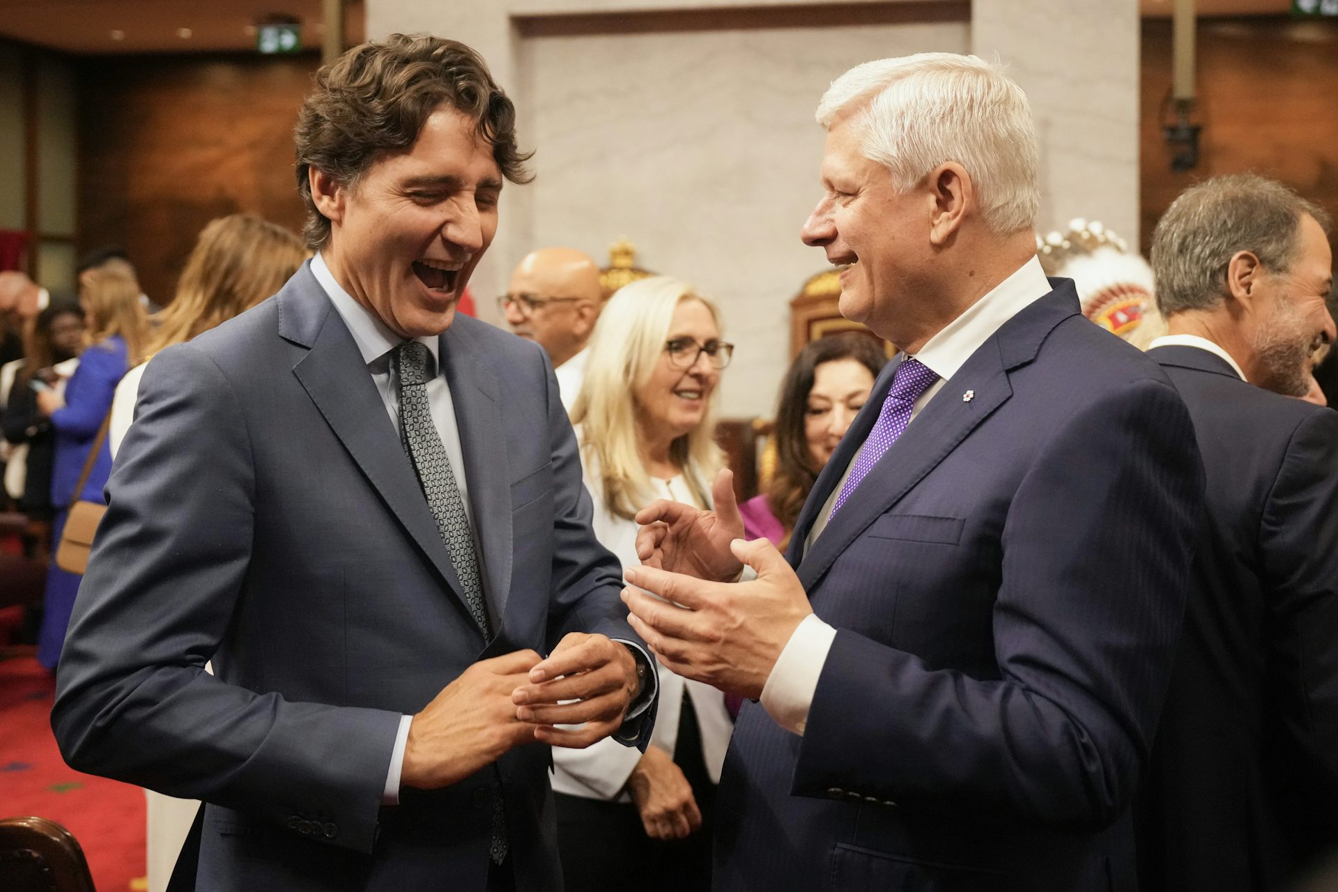 For the young man with dark hair laughs while talking to an elderly man with white hair.