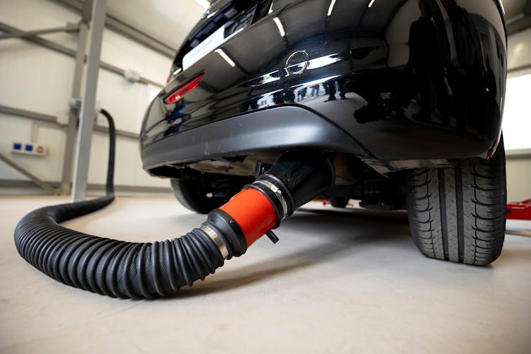 car with hose on exhaust, emissions test.