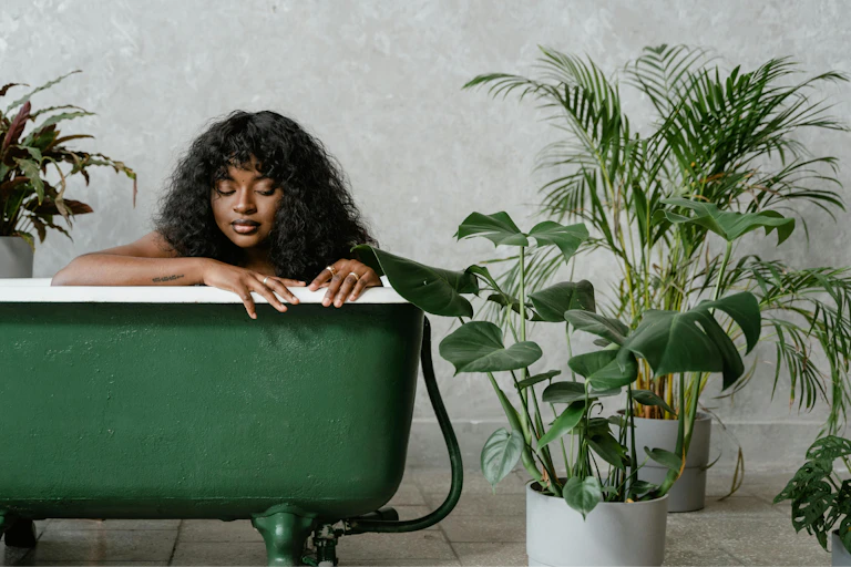 A woman relaxes in a green bath.