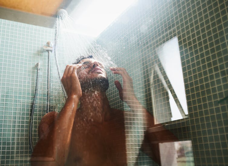 A man enjoys a hot shower.