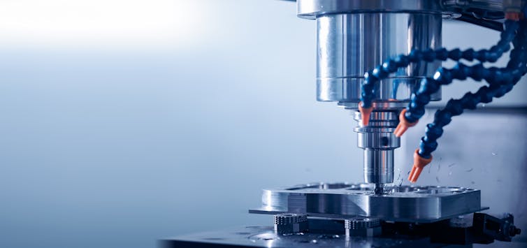 Closeup CNC milling machine during operation. Produced cutting metal parts