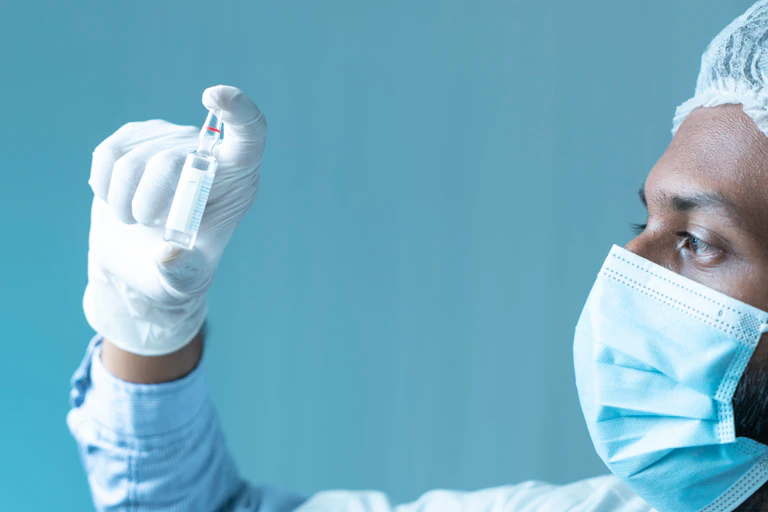 A scientist holds a vial of the M72 TB vaccine.