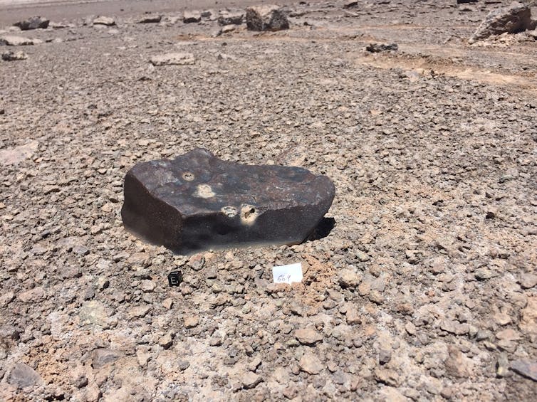 Una roca oscura sobre tierra más clara en el desierto de Atacama