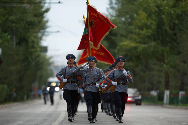 Russian soldiers carrying flags in a Mongolian ceremony.