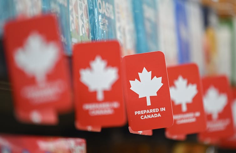 La fila del pequeño rojo 'preparado en personajes canadienses a lo largo del estante de comestibles.
