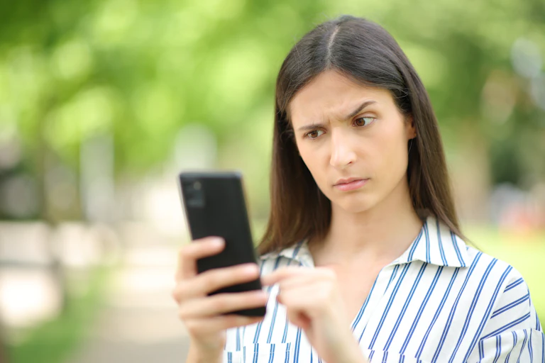 Una chica levanta una ceja ante lo que ve en su móvil