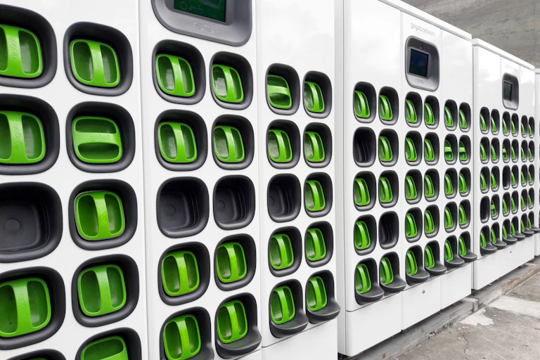 A line of about 60 boxes with modern green handles where drivers can pull out replacement electric batteries