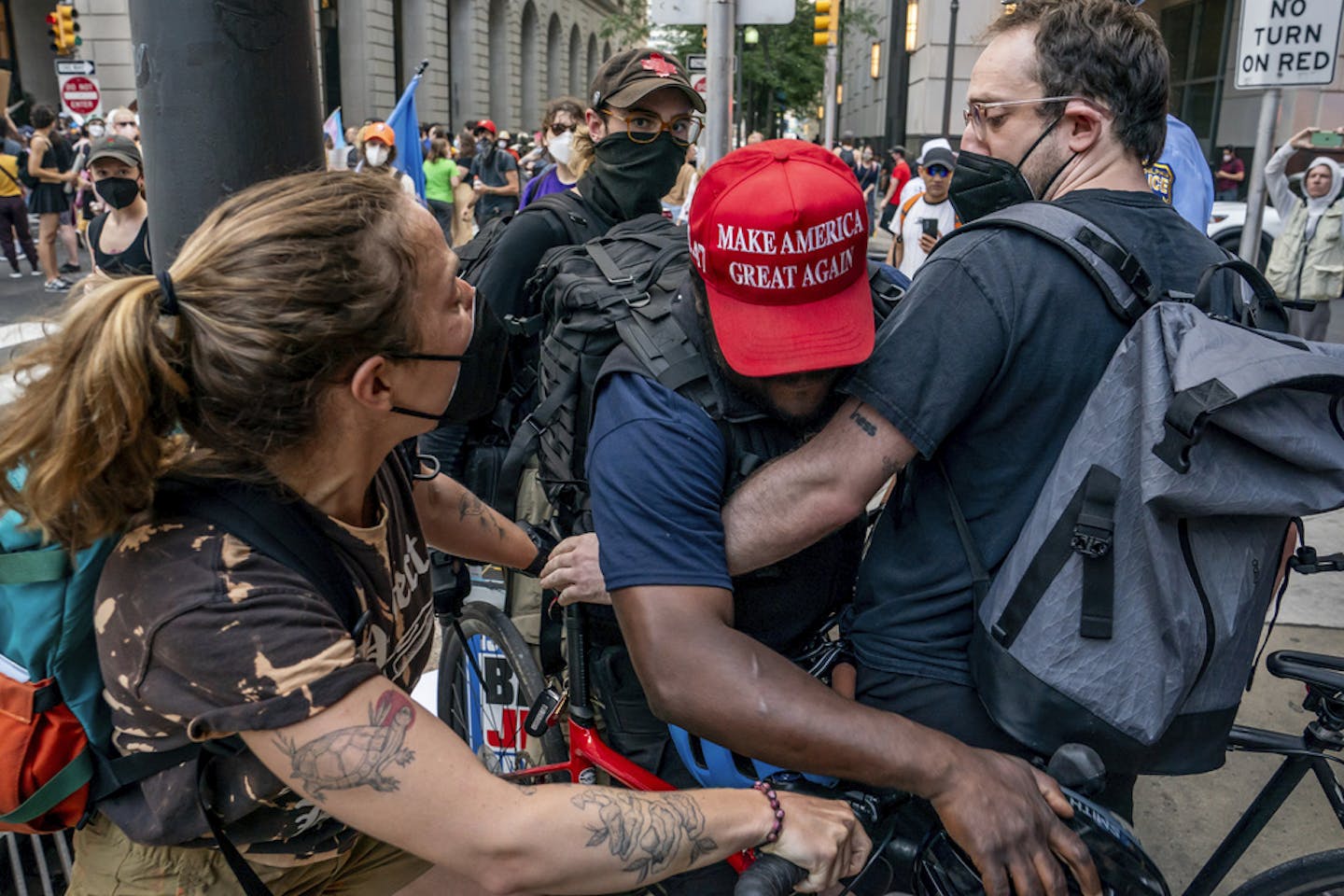 A man struggles through a crowd of protesters.