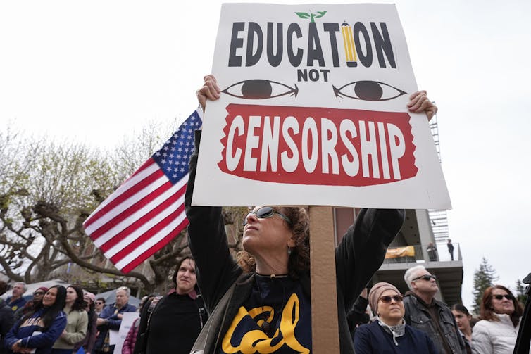 A woman holds up a sign at a protest.