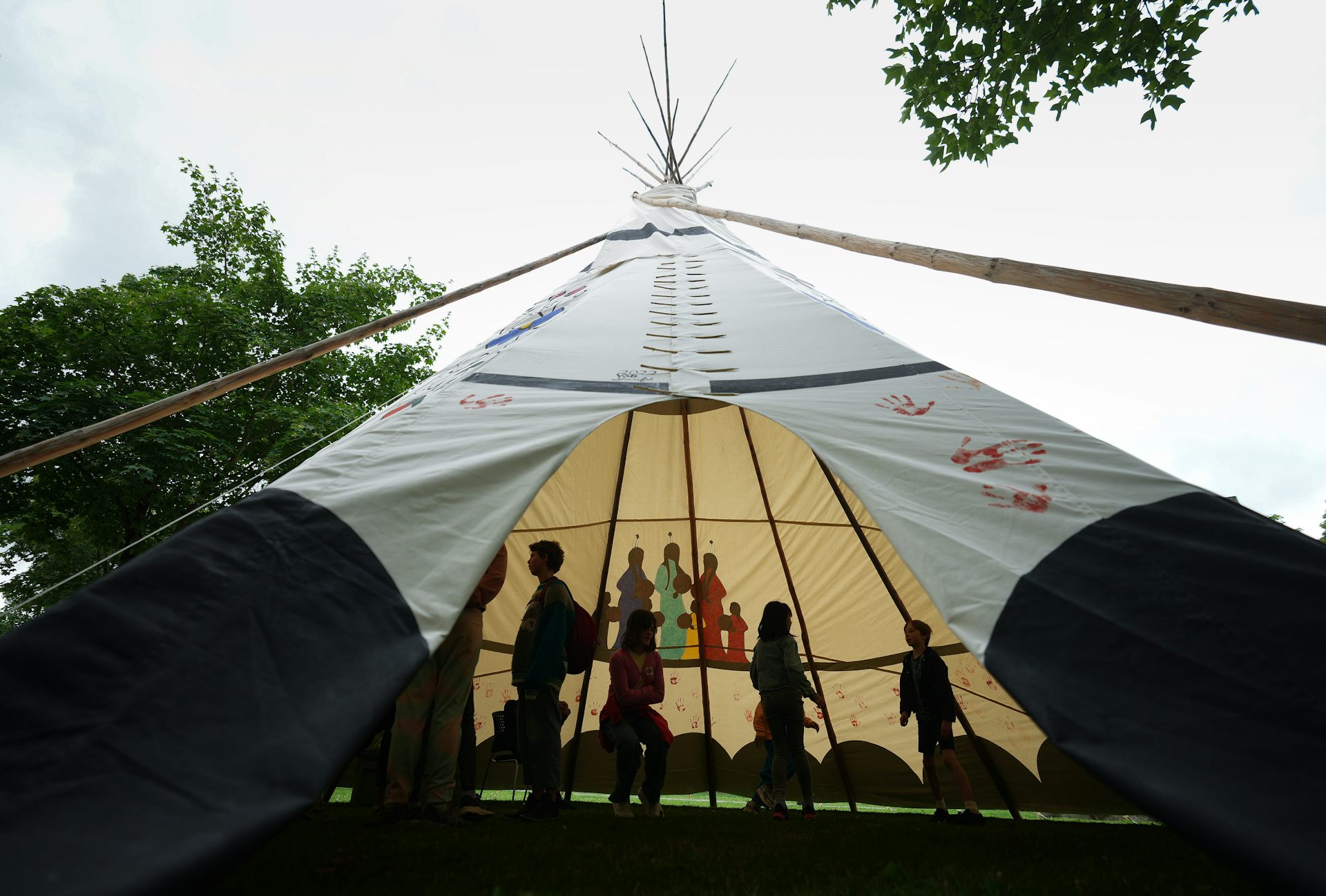 People inside a teepee structure. 