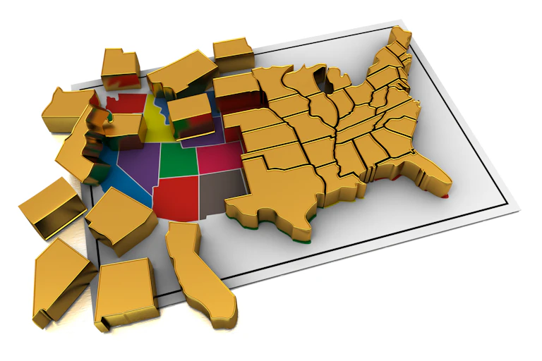 A puzzle, being disassembled, made up of pieces for each of the US states.