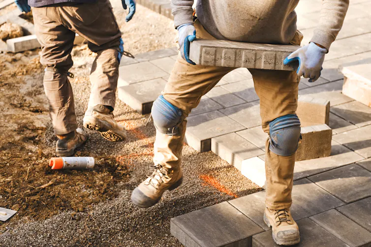 landscapers laying tiles outdoors