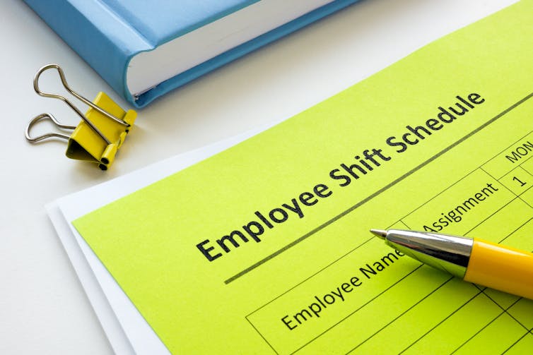 sheet of paper on clipboard, reading 'Employee Shift Schedule'