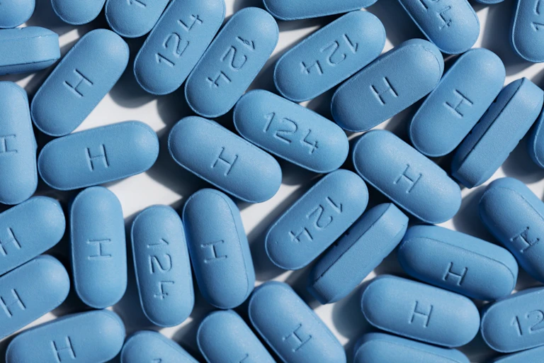 Blue HIV pills on light coloured background