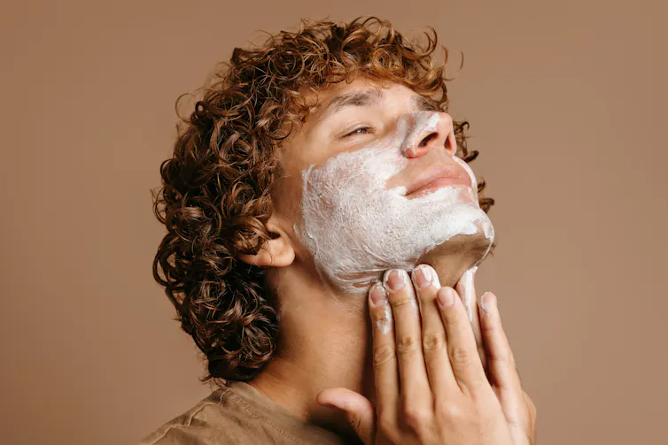 Um jovem aplicando uma máscara facial