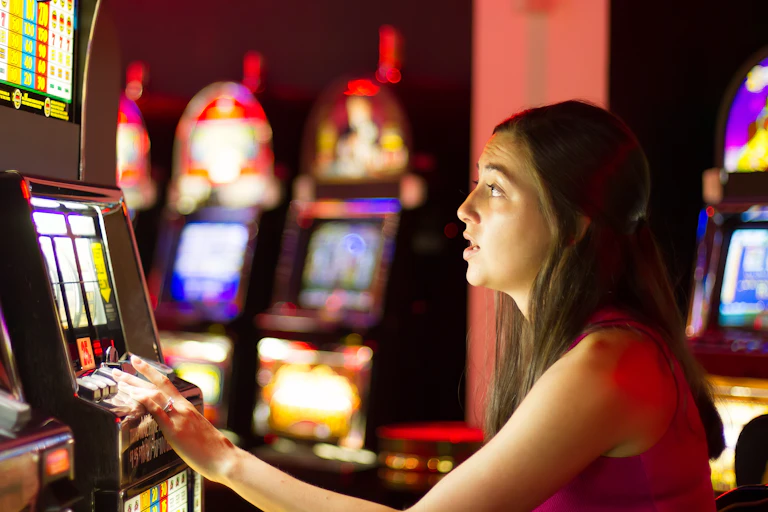 Woman sits playing on slot machine