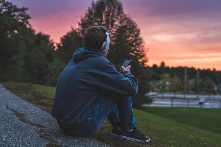Un adolescent écoute de la musique avec un casque.