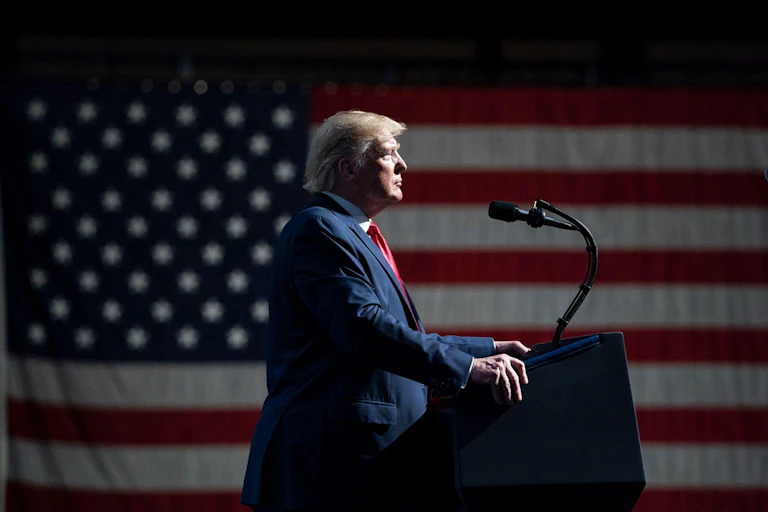 Donald Trump in front a huge US flag.